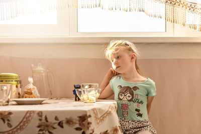 Portrait of a little girl toddler at the dining table. poor appetite.