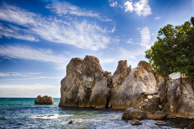 Rock formations by sea against sky