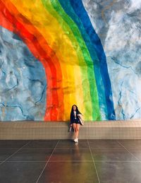 Full length of woman on multi colored wall