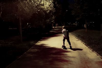 Rear view of boy riding motorcycle on street