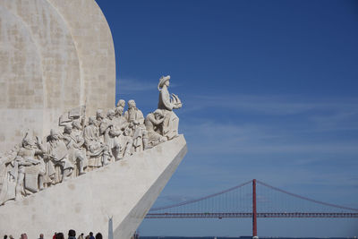 Low angle view of statue against blue sky padrao dos descobrimentos, lisbon, portugal