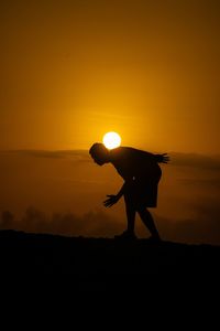 Silhouette people standing on street against sky during sunset