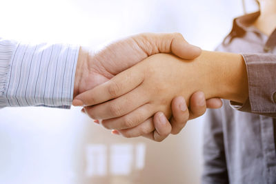 Midsection of couple holding hands