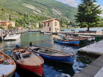 Boats moored in canal amidst buildings in city