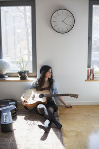 Young woman playing an acoustic guitar