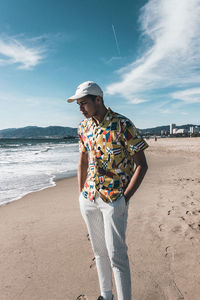 Man standing at beach against sky