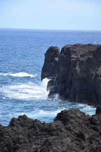 Rock formation on beach against clear sky