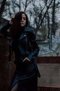 Portrait of young woman standing in forest