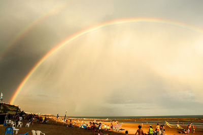 Scenic view of rainbow over beach against sky