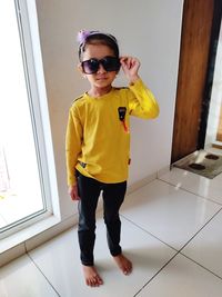 Portrait of boy standing on floor at home