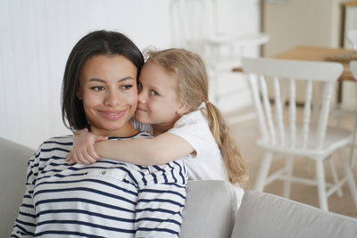 Sincere loving cute little daughter cuddling foster mother, showing love, tender feelings