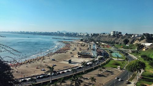 High angle view of city by sea against clear sky