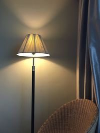 Illuminated lamp by chair at home