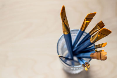 High angle view of paint brushes in glass on table