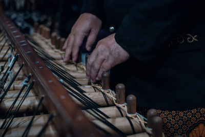 Midsection of man playing angklung 