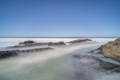 Scenic view of sea against clear blue sky