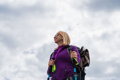 Low angle view of woman standing against sky