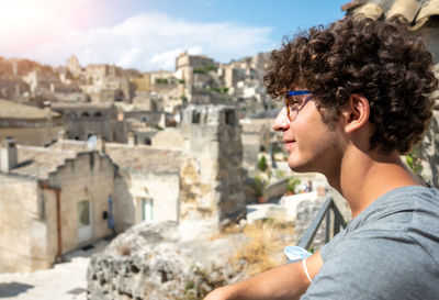 Side view of young man looking through window