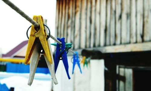 Close-up of clothes pegs hanging on clothesline