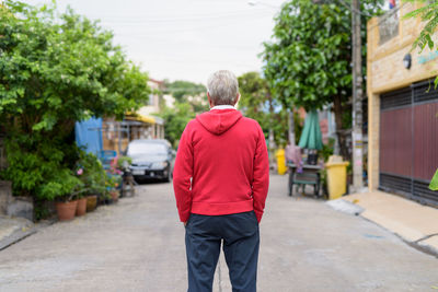 Rear view of man walking on street in city