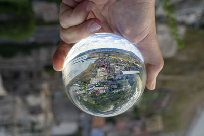 Close-up of hand holding glass with reflection