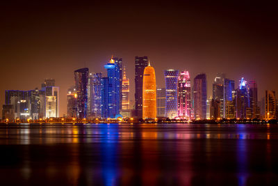 Coloful illuminated skyline of doha at night, qatar, middle east against dark sky