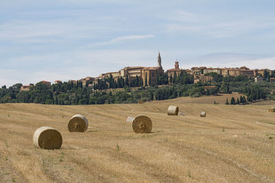 Hay bales on field against sky