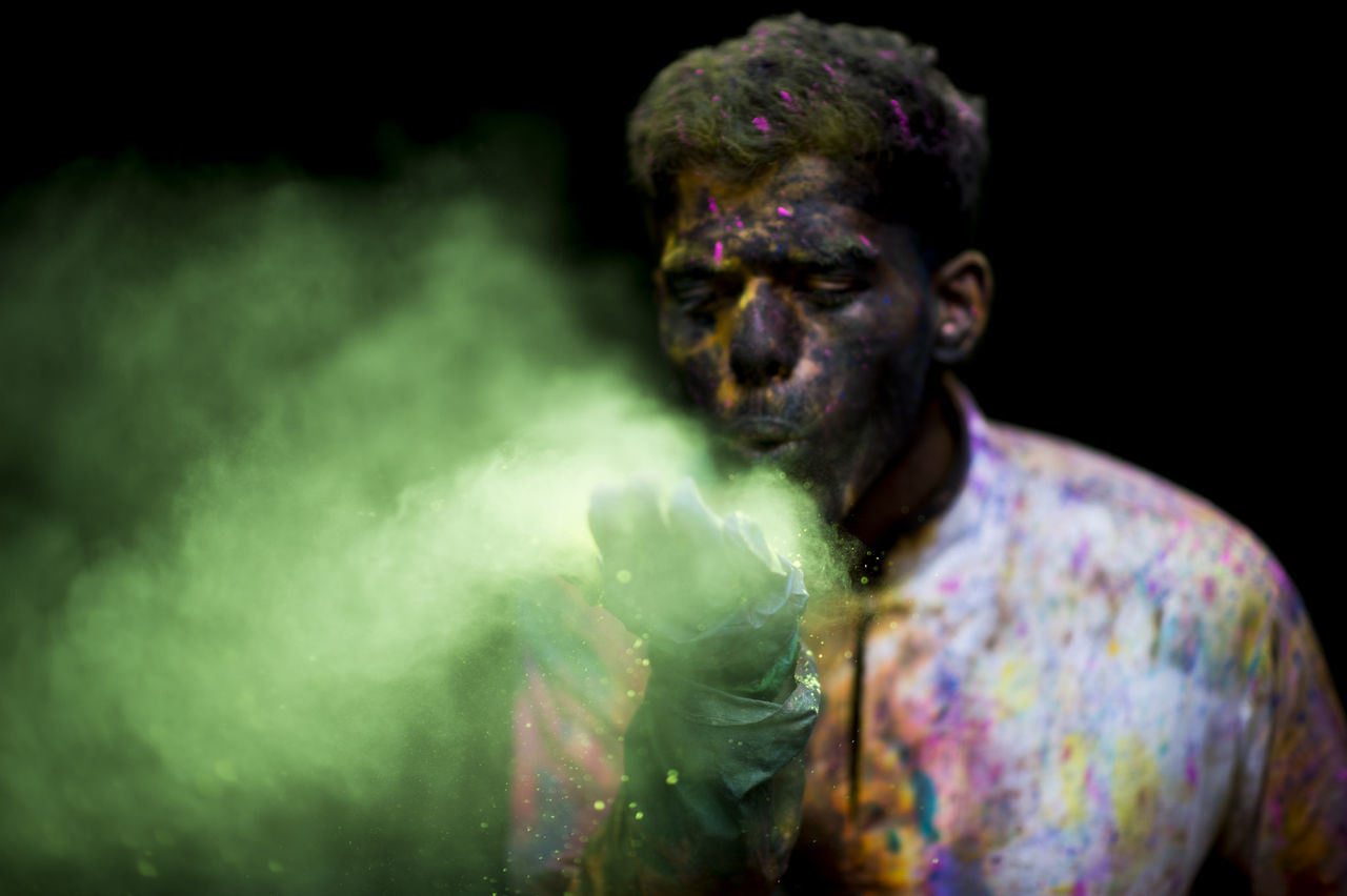 CLOSE-UP OF MAN WITH MULTI COLORED BACKGROUND