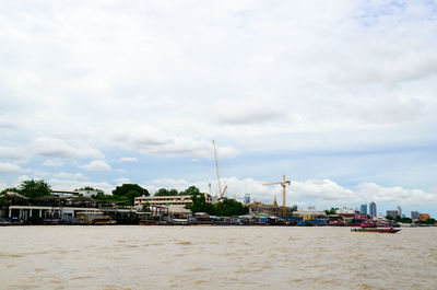 Ship in sea against sky in city