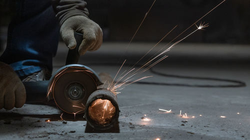 Cropped hands of man cutting metal in workshop