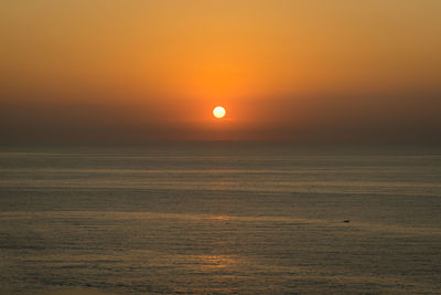 Scenic view of sea against orange sky