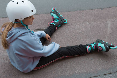 High angle view of boy sitting on street