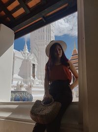 Portrait of young woman sitting by window