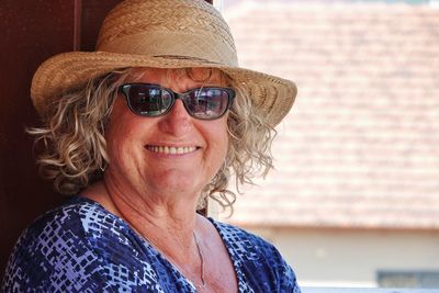 Portrait of a woman wearing sunglasses against wall