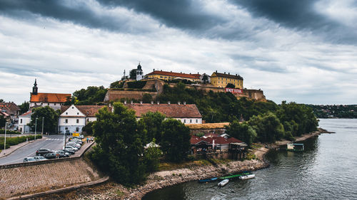 High angle view of buildings by river against sky