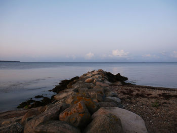 Scenic view of rocks on beach against sky