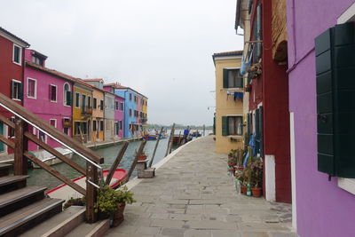 Footpath amidst buildings against sky