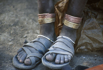 Low section of dirty legs in slipper at serengeti national park during sunny day