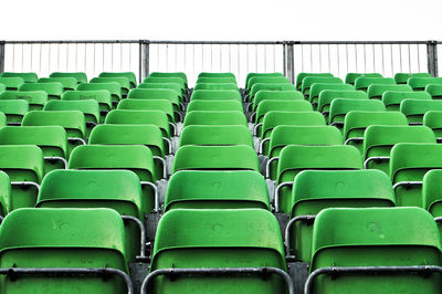 Low angle view of empty green chairs in stadium