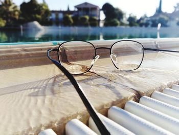 Close-up of sunglasses with swimming pool