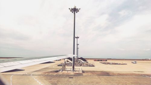 Airplane on airport runway against sky