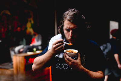 Man eating food while standing at market