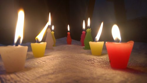 Lit candles burning in darkroom