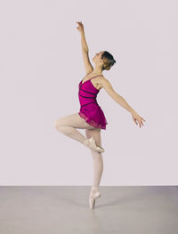 Full length of woman dancing against white background