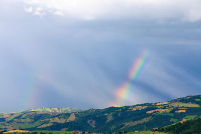 Low angle view of rainbow over mountain against sky