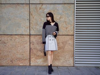 Full length of woman standing on footpath