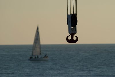 Sailboat on sea against clear sky during sunset