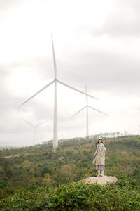 Rear view of man standing on field against sky