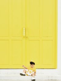 Side view of woman standing against wall