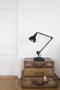 Stack of vintage suitcases with an antique table lamp on top